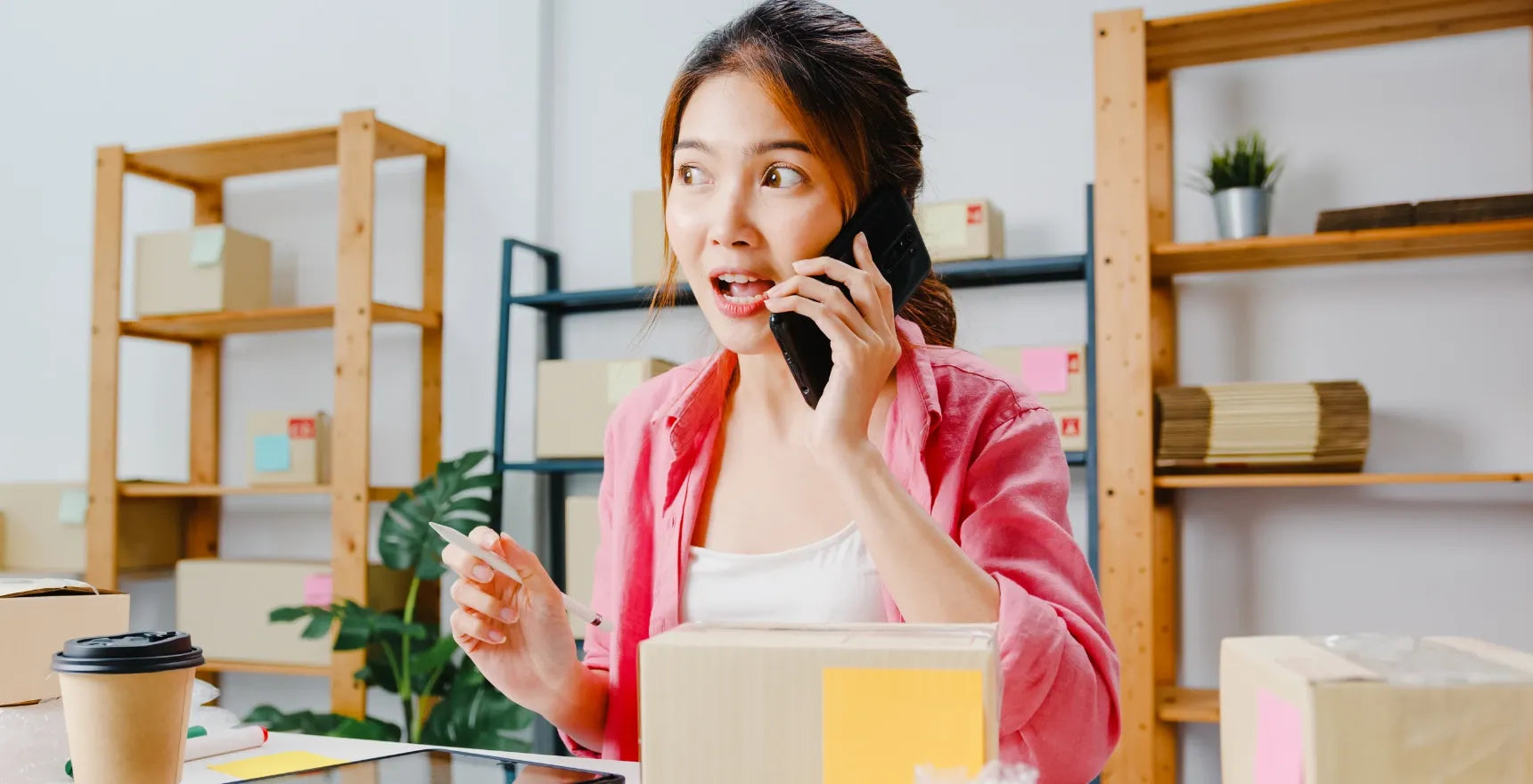 Woman on the phone in a room with shelves and boxes