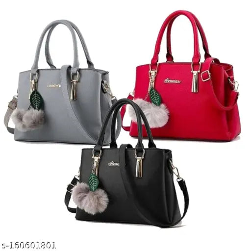 Three handbags in gray, red, and black with pom-pom decorations on a white background.